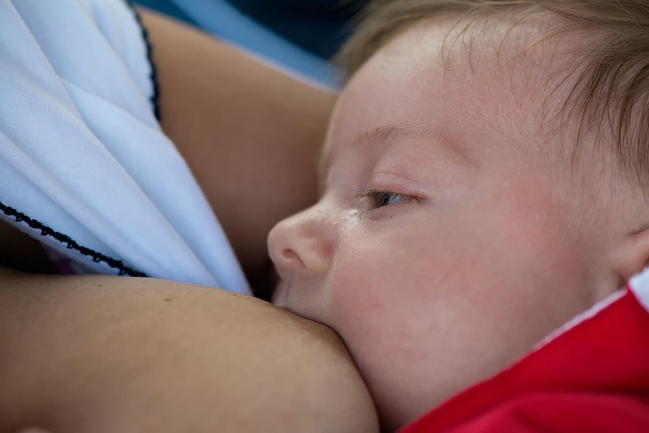 Mother feeding newborn baby with bottle