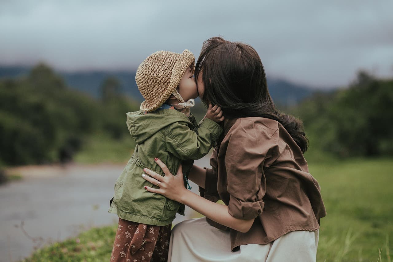 Child sitting with a caring adult in a warm, comfortable room, talking calmly and feeling supported