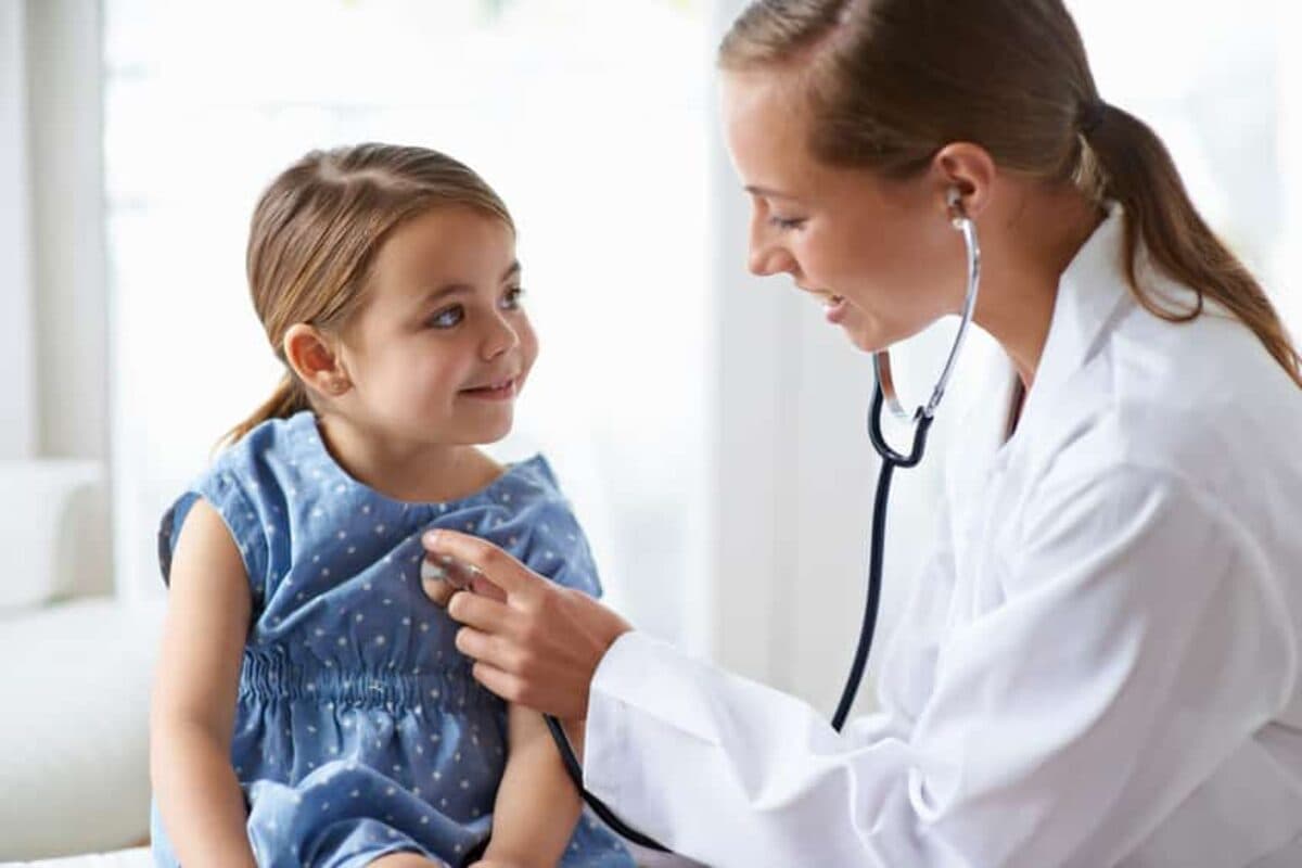 Pediatrician performing a well-child checkup with a young patient