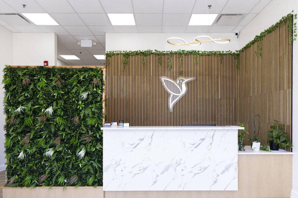 Reception area with a green accent wall at Hummingbird Pediatrics