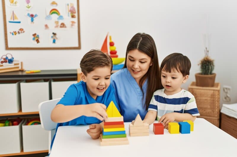 Pediatrician conducting developmental screening with child using colorful assessment tools